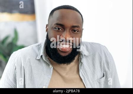Close-up photo of positive confident handsome successful african american young man in stylish casual wear, male freelancer, executive, product manager, looking at the camera, smiling friendly Stock Photo
