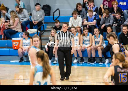 A female IHSAA referee officiates a girls' high school basketball game at Lakewood Park Christian School in Auburn, Indiana, USA. Stock Photo