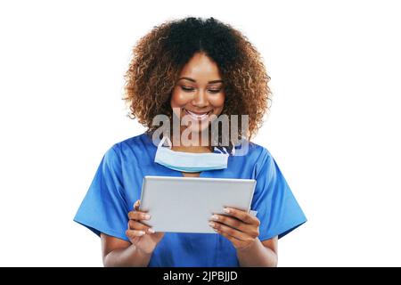 Technology thats tailored to her medical needs. Studio shot of an attractive young nurse using a digital tablet against a white background. Stock Photo