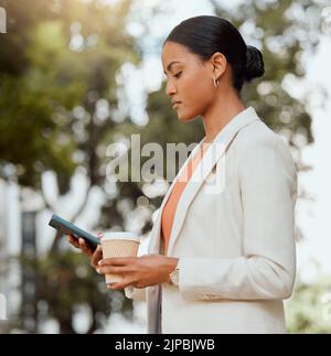 Business woman texting on phone, booking and ordering city taxi, lift or ride in morning commute to work. Serious and busy professional with coffee Stock Photo