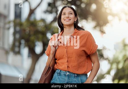 Stylish, happy and trendy student walking in a city, commuting to a college and enjoying a weekend break downtown. Smiling, edgy or funky woman Stock Photo