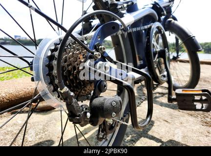 Bicycle gear wheels in close up with mechanic gears cassette and chain at the rear wheel of folding bike Stock Photo