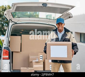 Doing his delivery rounds. Portrait of a courier unloading boxes from a delivery van. Stock Photo