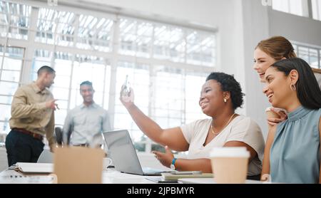Diverse, creative and marketing team taking selfie in an office while working on a laptop together. Multiracial, happy and beautiful group of female Stock Photo