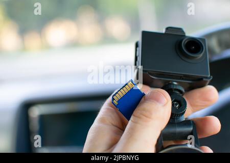 a faulty flash memory card from the DVR, an action camera in the driver hands inside the car with an empty space for inserting text Stock Photo