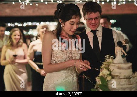 The cutting of the cake. a cheerful young bride and groom cutting the wedding cake together inside of a building during the day. Stock Photo