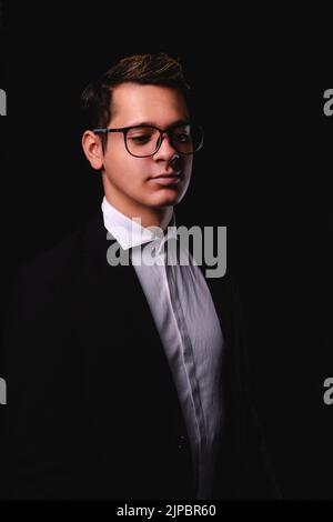 Businessman on a black background. Man dressed in a suit, white shirt and glasses. Elegantly dressed business executive. High quality photo Stock Photo