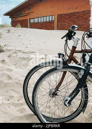 two sports bikes stand side by side on white sandy beach. Template free space pattern wallpaper mockup text. Summer background. Bicycle adventure trip Stock Photo