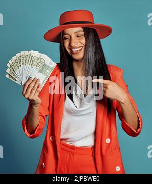 Rich young woman holding cash, competition or lottery winnings pointing looking stylish, elegant and trendy. Happy, excited and celebrating female Stock Photo