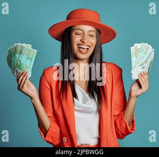 Money, currency and winning the lottery with a young woman holding cash and looking happy, excited and celebrating success. Female cheering with Stock Photo