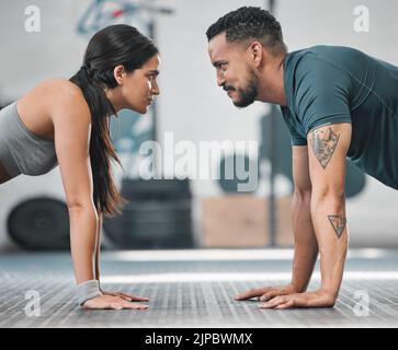 Fitness, gym and training couple doing an exercise workout and living an active, healthy and sporty lifestyle together. Serious, toned and athletic Stock Photo