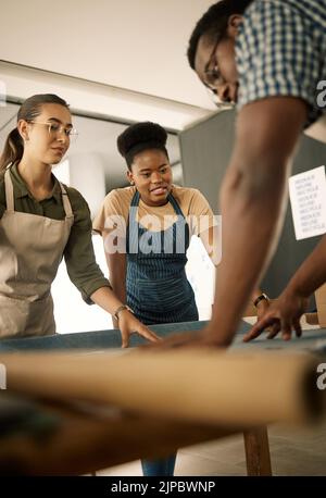 Creative, fashion designer tailors working on fabric for stylish clothing in modern sewing design studio workshop. Group of artistic and professional Stock Photo