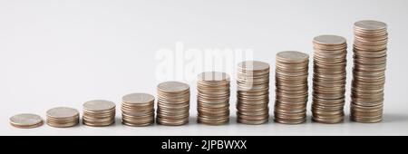 Stacks of silver coins in ascending order on light gray background Stock Photo