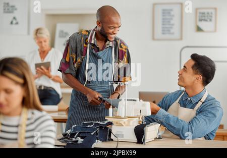 Fashion designers, colleagues and men sewing clothes in a workshop. Happy, diverse and smiling young creatives planning garment designs in a textile Stock Photo