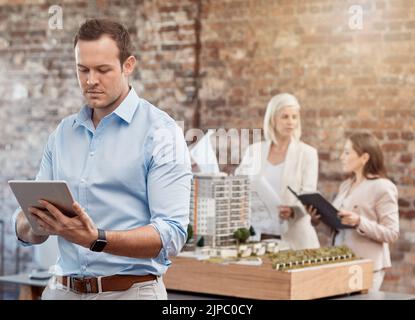 Serious professional architect design engineer working on digital tablet for building plans in modern office at architecture company. Creative Stock Photo