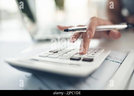 Calculator, banking and finance with an accountant, financial planner or insurance broker working in an office or bank. Closeup of a hand typing Stock Photo