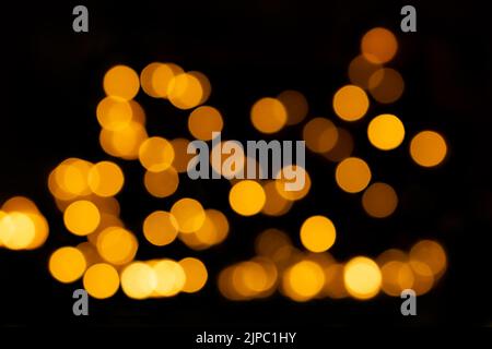 Yellow defocused lights, bokeh on black background, overlay. Design element. Christmas, New Year Stock Photo