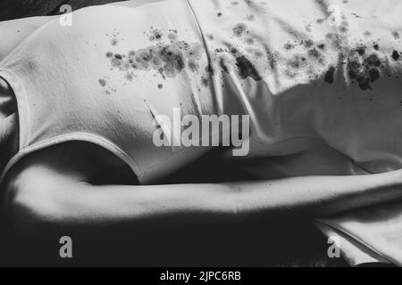 A murdered and tortured Ukrainian woman in a white dress and bloodstains lies on the floor of the house, a protest action of Ukrainian women Stock Photo