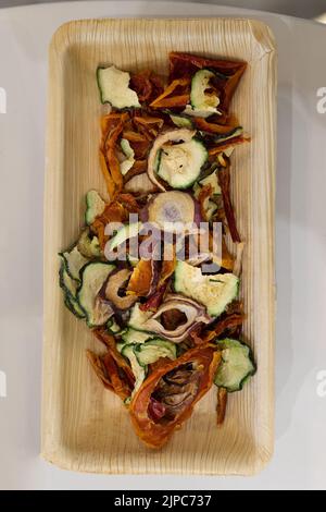 Small Wooden Tray with Thin Slices of Zucchini, Tomatoes, and other Freshly Dried Vegetables.. Stock Photo