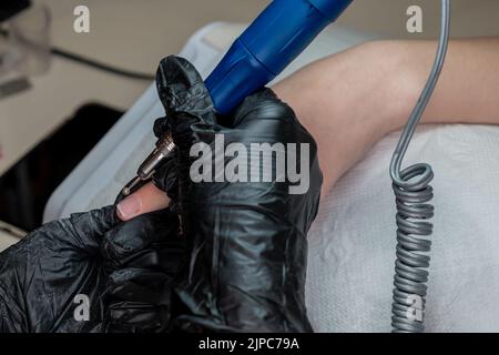 Neat manicure, cuticle cleaning by a master in the professional salon Stock Photo