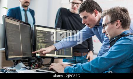 Startup business problem solving. Software developers working on desktop computer. Stock Photo