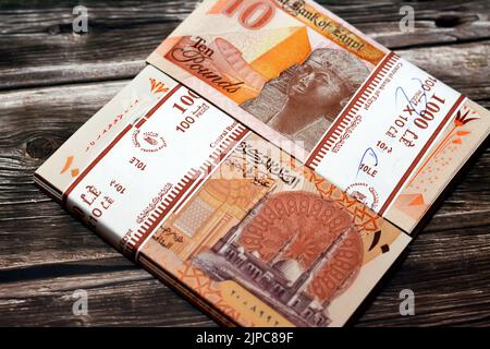 Stack of new first Egyptian 10 LE EGP ten pounds plastic polymer banknote features Administrative capital's grand mosque Al-Fattah Al-Aleem, the pyram Stock Photo