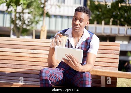 african american young man with tablet computer and take away coffee Stock Photo