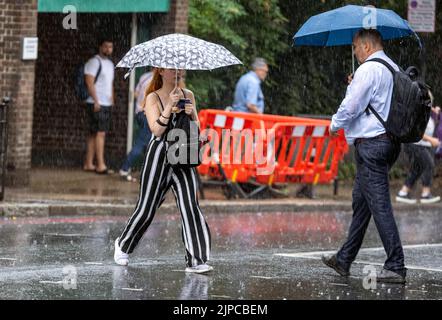 Wet weather finally in London after rough conditions  heavy showers caught out some others had come prepared with umbrellas around Highgate North  Lon Stock Photo