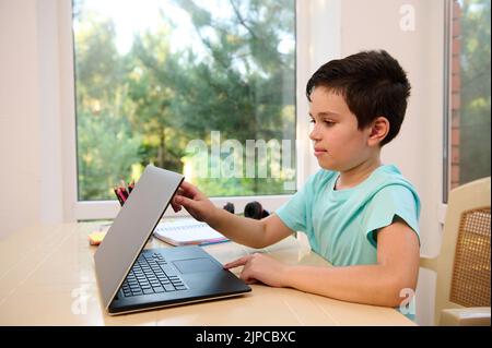 Handsome Caucasian schoolboy starting a new semester of an academic year in an online school. Homeschooling concept Stock Photo