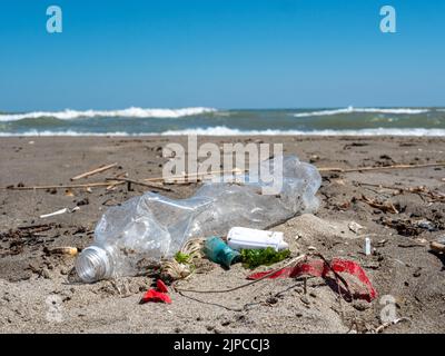 Plastic waste lies in the sand on the beach Stock Photo