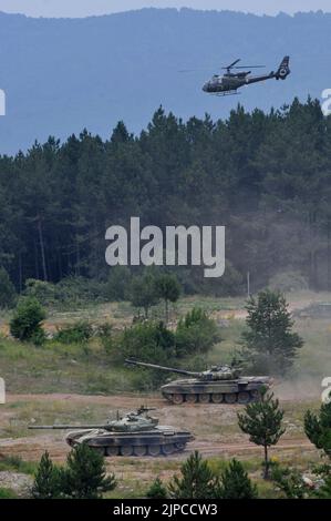 Serbian Army main battle tank M84 (version of Soviet T-72) and M80 armored personal carrier (APC) crews during exercise drill at military range Stock Photo