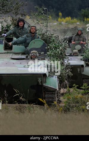 Serbian Army main battle tank M84 (version of Soviet T-72) and M80 armored personal carrier (APC) crews during exercise drill at military range Stock Photo