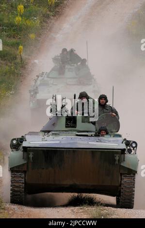 Serbian Army main battle tank M84 (version of Soviet T-72) and M80 armored personal carrier (APC) crews during exercise drill at military range Stock Photo