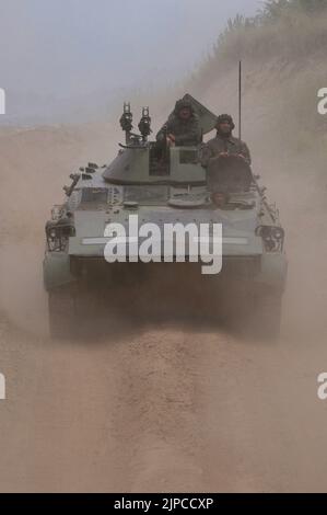 Serbian Army main battle tank M84 (version of Soviet T-72) and M80 armored personal carrier (APC) crews during exercise drill at military range Stock Photo