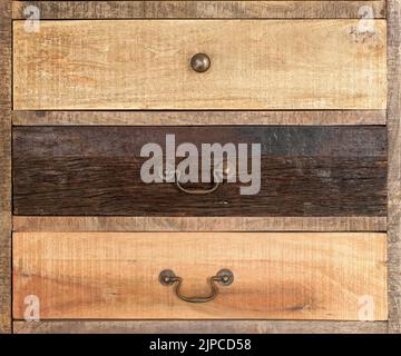 An antique wooden chest of drawers with metal handles, different kind old wooden boxes Stock Photo