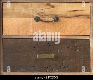 An antique wooden chest of drawers with metal handles, different kind old wooden boxes Stock Photo