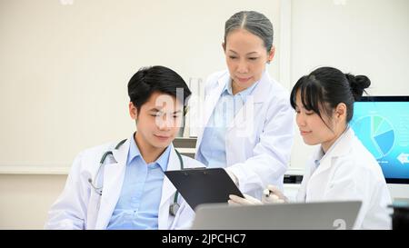 A team of Asian scientist or specialist planning and brainstorming on their Microbiology development research and experiment together in the science l Stock Photo