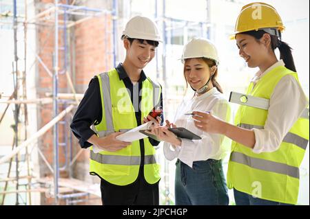 A confident Asian businesswoman in the construction site with two professional Asian engineer. Engineer or architect working concept Stock Photo