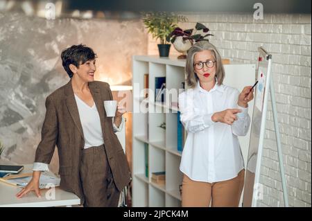 Colleagues discussing project details and looking involved Stock Photo