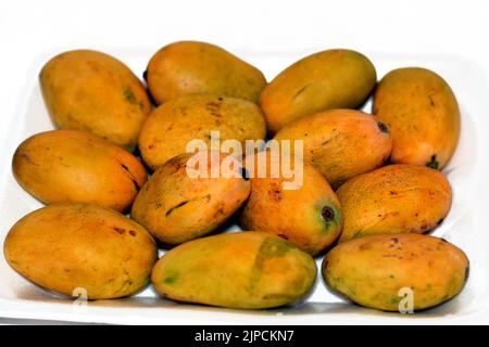 fresh Mango fruit isolated on a white background, a mango is an edible stone fruit produced by the tropical tree Mangifera indica that varies in size, Stock Photo