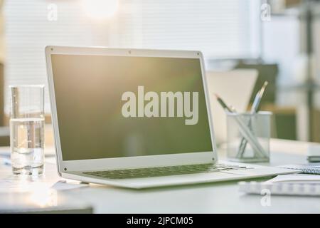 Close-up of laptop with blank screen standing on table of business person at office Stock Photo