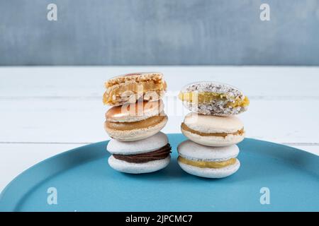 Closeup of a stack of macarons filled with chocolate ganache, dulce de leche and passion fruit cream. Stock Photo