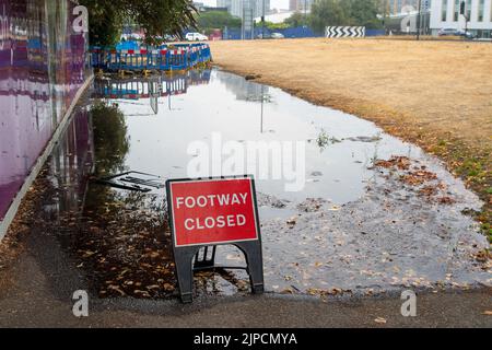Slough, Berkshire, UK. 17th August, 2022. Following a burst water main, water runs along a path outside the former Thames Valley University Site in Slough. It has been cordoned off by Thames Water but they have left the site. Thames Water have been much criticised for the number of outstanding water leaks that have yet to be fixed. Thames Water have today announced a hose pipe ban starting from Wednesday 24th August. Credit: Maureen McLean/Alamy Live News Stock Photo