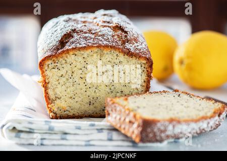 Lemon cake with poppy seeds, sliced on a gray background. Stock Photo