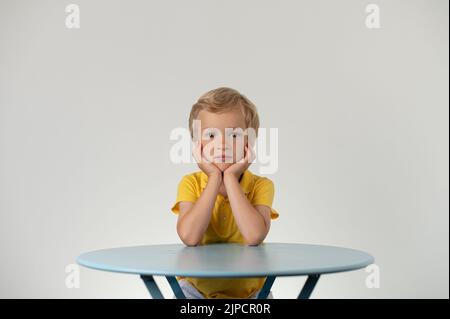 Boy with sitting at a table, school education Stock Photo