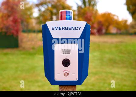 Panic alarm for call to police, emergency button in public park. Blue box with video camera and red blue warning light on top Stock Photo
