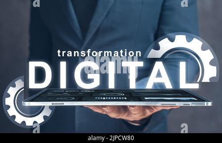 digital transformation. businessman holds in his hand tablet with text digital transformation and gears. Digital modernization and business processes Stock Photo