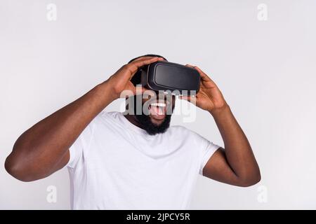 Photo of cheerful excited man wear casual t-shirt playing 3d game empty space isolated white color background Stock Photo