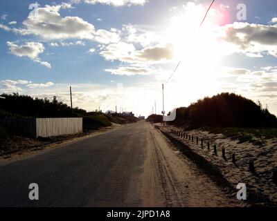 An empty road in Quequen under a blue cloudy sky on a sunny day Stock Photo