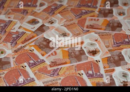 Pile of the new first Egyptian 10 LE EGP ten pounds plastic polymer banknote features Administrative capital's grand mosque Al-Fattah Al-Aleem, the py Stock Photo